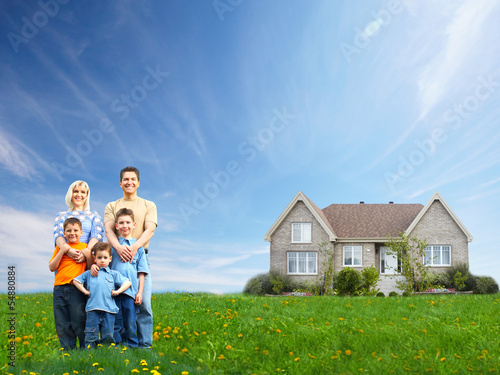 Photo: Happy family near new house. Happy family near new house.