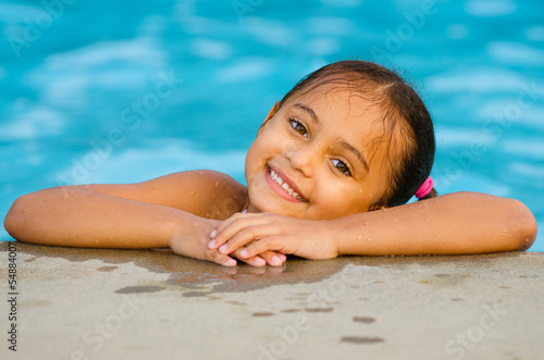 Photo: Portrait of happy pretty mixed race child by side of pool Portrait of happy pretty mixed race child by side of pool