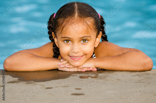 Photo: Portrait of happy pretty mixed race child by side of pool Portrait of happy pretty mixed race child by side of pool