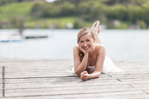 Photo: Joyful woman relaxing on a wooden deck at the sea Joyful woman relaxing on a wooden deck at the sea