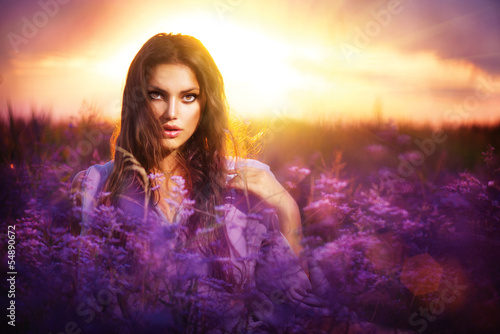 Photo: Beauty Girl Lying on a Meadow with Violet Flowers Beauty Girl Lying on a Meadow with Violet Flowers