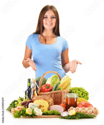 Photo: Young woman with assorted grocery products isolated on white Young woman with assorted grocery products isolated on white