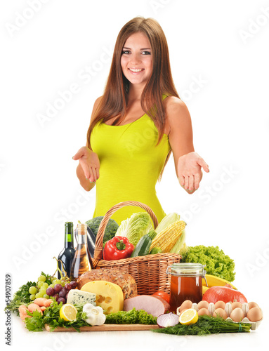 Photo: Young woman with assorted grocery products isolated on white Young woman with assorted grocery products isolated on white