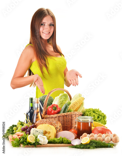 Photo: Young woman with assorted grocery products isolated on white Young woman with assorted grocery products isolated on white