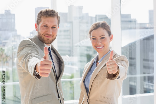 Photo: Smiling business team giving thumbs up Smiling business team giving thumbs up