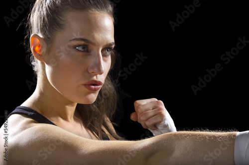 Photo: female MMA fighter punching. black background female MMA fighter punching. black background