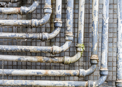 Photo: Series of parallel old pipes on wall Series of parallel old pipes on wall