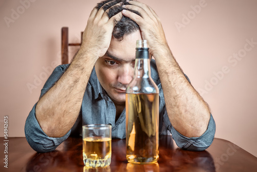 Photo: Drunk and depressed hispanic man suffering a headache Drunk and depressed hispanic man suffering a headache