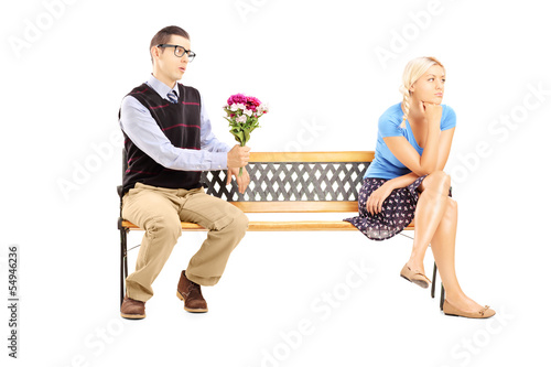 Photo: Male giving a bunch of flowers and uninterested female sitting Male giving a bunch of flowers and uninterested female sitting