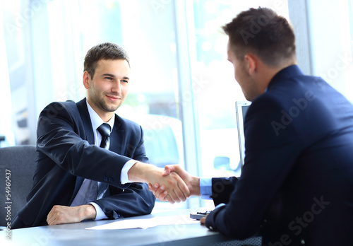Photo: businessman shaking hands to seal a deal with his partner businessman shaking hands to seal a deal with his partner