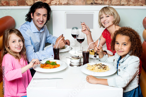 Photo: Family eating together in a restaurant Family eating together in a restaurant