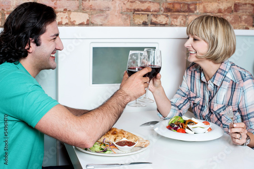 Photo: Couple toasting over a restaurant table Couple toasting over a restaurant table