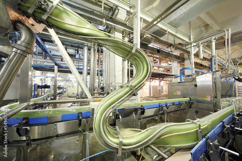 Photo: Green cans move fast on conveyor in factory Green cans move fast on conveyor in factory