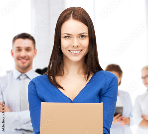 Photo: smiling woman holding cardboard box smiling woman holding cardboard box