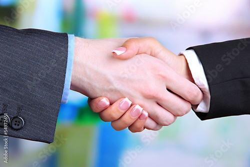 Photo: Business handshake on bright background Business handshake on bright background