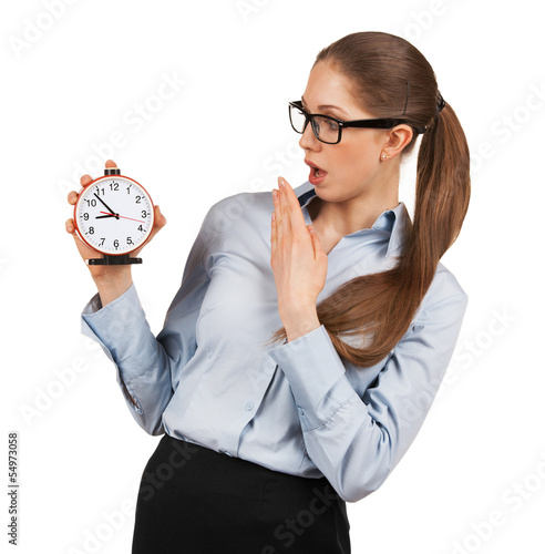 Photo: Surprised woman holding an alarm clock in a hand Surprised woman holding an alarm clock in a hand