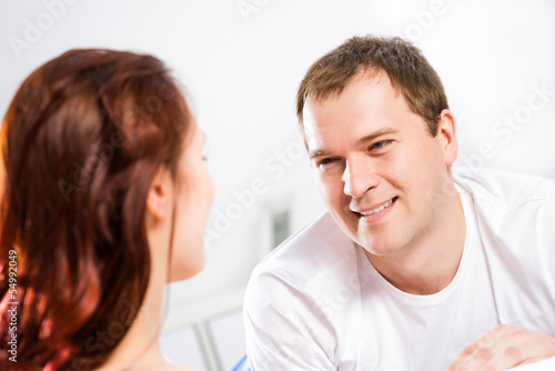 Photo: young man lying in bed with his girlfriend young man lying in bed with his girlfriend