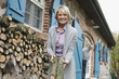 Photo: Deutschland, Kratzeburg, erwachsene Frau mit Brennholz, Senior, Rentner im Hintergrund Deutschland, Kratzeburg, erwachsene Frau mit Brennholz, Senior, Rentner im Hintergrund