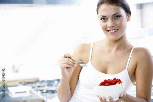 Photo: Junge Frau hält Schüssel mit Himbeeren Junge Frau hält Schüssel mit Himbeeren