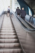 Photo: Deutschland, Bayern, München, Drei Geschäftsleute auf Rolltreppe, Geschäftsfrau mit Handy Deutschland, Bayern, München, Drei Geschäftsleute auf Rolltreppe, Geschäftsfrau mit Handy