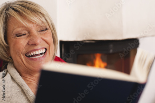 Photo: Deutschland, Kratzeburg, ältere Frau, Seniorin liest Buch und lächelt Deutschland, Kratzeburg, ältere Frau, Seniorin liest Buch und lächelt