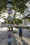 Photo : Österreich, Steiermark, Bad Radkersburg, Erwachsene fahren Fahrrad mit Straßennamen Zeichen Österreich, Steiermark, Bad Radkersburg, Erwachsene fahren Fahrrad mit Straßennamen Zeichen