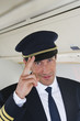 Photo: Deutschland, Bayern, München, Pilot salutiert in der Business Class Flugzeugkabine, Lächeln Deutschland, Bayern, München, Pilot salutiert in der Business Class Flugzeugkabine, Lächeln