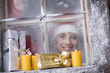 Photo: Österreich, Salzburger Land, junge Frau schaut durch Fenster, Pakete und Kerzen auf der Fensterbank Österreich, Salzburger Land, junge Frau schaut durch Fenster, Pakete und Kerzen auf der Fensterbank