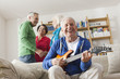 Photo: Deutschland, Leipzig, Senior, Rentner spielt E-Gitarre, Mann und Frau im Hintergrund Deutschland, Leipzig, Senior, Rentner spielt E-Gitarre, Mann und Frau im Hintergrund