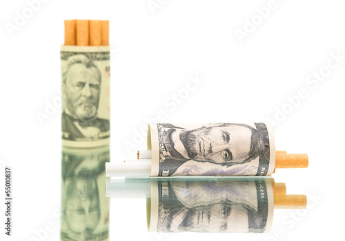 Photo: expensive habit. money and cigarettes on white background expensive habit. money and cigarettes on white background