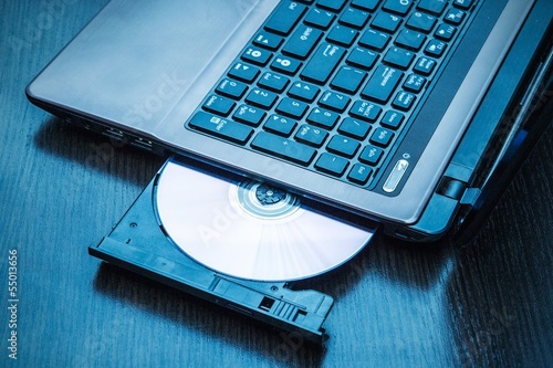 Photo: Laptop with open CD - DVD drive. Abstract light composition Laptop with open CD - DVD drive. Abstract light composition