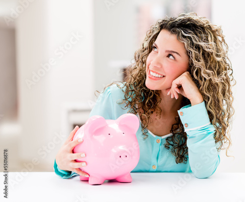 Photo: Thoughtful woman with a piggybank Thoughtful woman with a piggybank