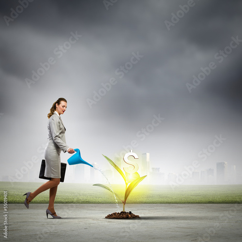 Photo: Business woman watering monet tree Business woman watering monet tree
