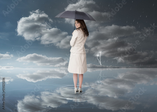Photo: Businesswoman holding a black umbrella Businesswoman holding a black umbrella