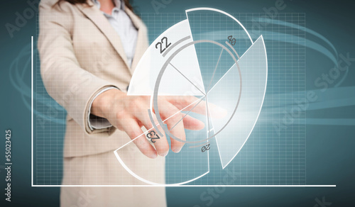 Photo: Businesswoman touching futuristic pie chart interface Businesswoman touching futuristic pie chart interface