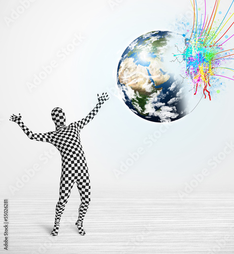 Photo: Funny man in body suit looking at colorful splatter earth Funny man in body suit looking at colorful splatter earth