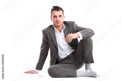 Photo: Portrait of business man sitting on the floor isolated Portrait of business man sitting on the floor isolated