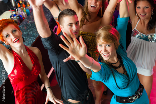 Photo: Young people dancing in club or disco, men and women Young people dancing in club or disco, men and women