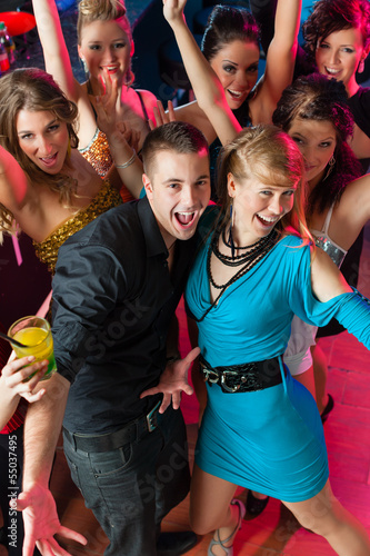 Photo: Young people dancing in club or disco, men and women Young people dancing in club or disco, men and women