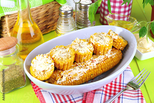Photo: Flavored boiled corn on plate on wooden table close-up Flavored boiled corn on plate on wooden table close-up