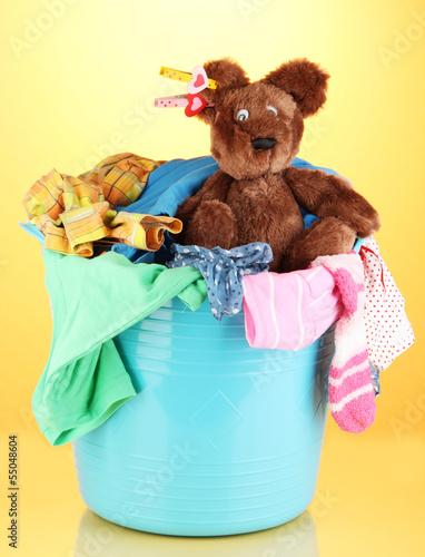 Photo: Blue laundry basket on orange background Blue laundry basket on orange background