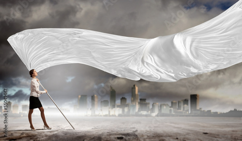 Photo: Businesswoman holding white flag Businesswoman holding white flag
