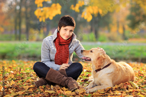 Photo: Beautiful young woman in a park with a dog Beautiful young woman in a park with a dog