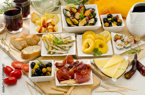 Photo: Spanish Cuisine. Variety of tapas on white plates. Spanish Cuisine. Variety of tapas on white plates.