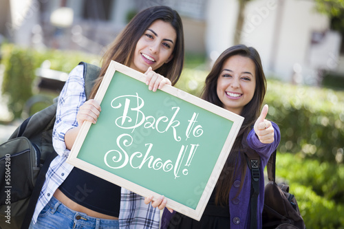 Photo: Mixed Race Female Students Holding Chalkboard With Back To Schoo Mixed Race Female Students Holding Chalkboard With Back To Schoo
