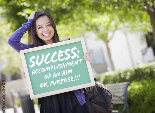Photo: Mixed Race Female Student Holding Chalkboard With Success and De Mixed Race Female Student Holding Chalkboard With Success and De