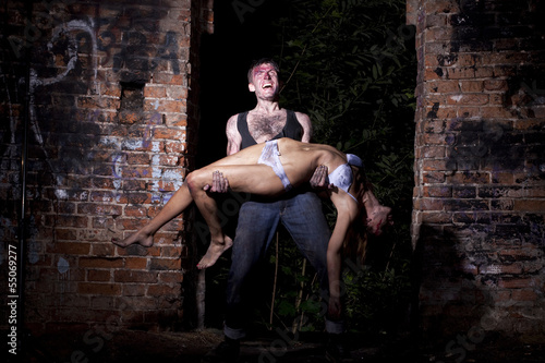 Photo: A strong man holding a bloody girl A strong man holding a bloody girl