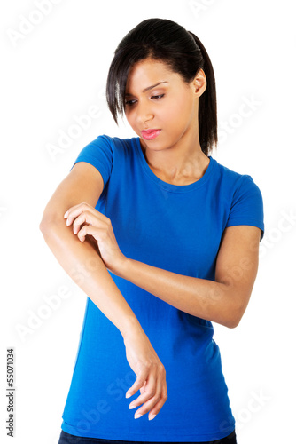 Photo: Young woman scratching her self. Young woman scratching her self.
