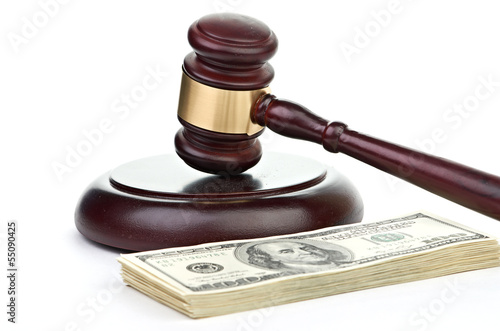 Photo: Law gavel on a stack of American money. Law gavel on a stack of American money.