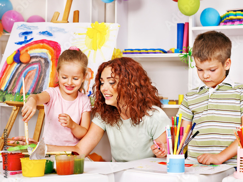 Photo: Child painting at easel. Child painting at easel.